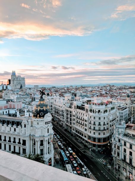 Vista panorámica de la ciudad con edificios y tráfico al atardecer.